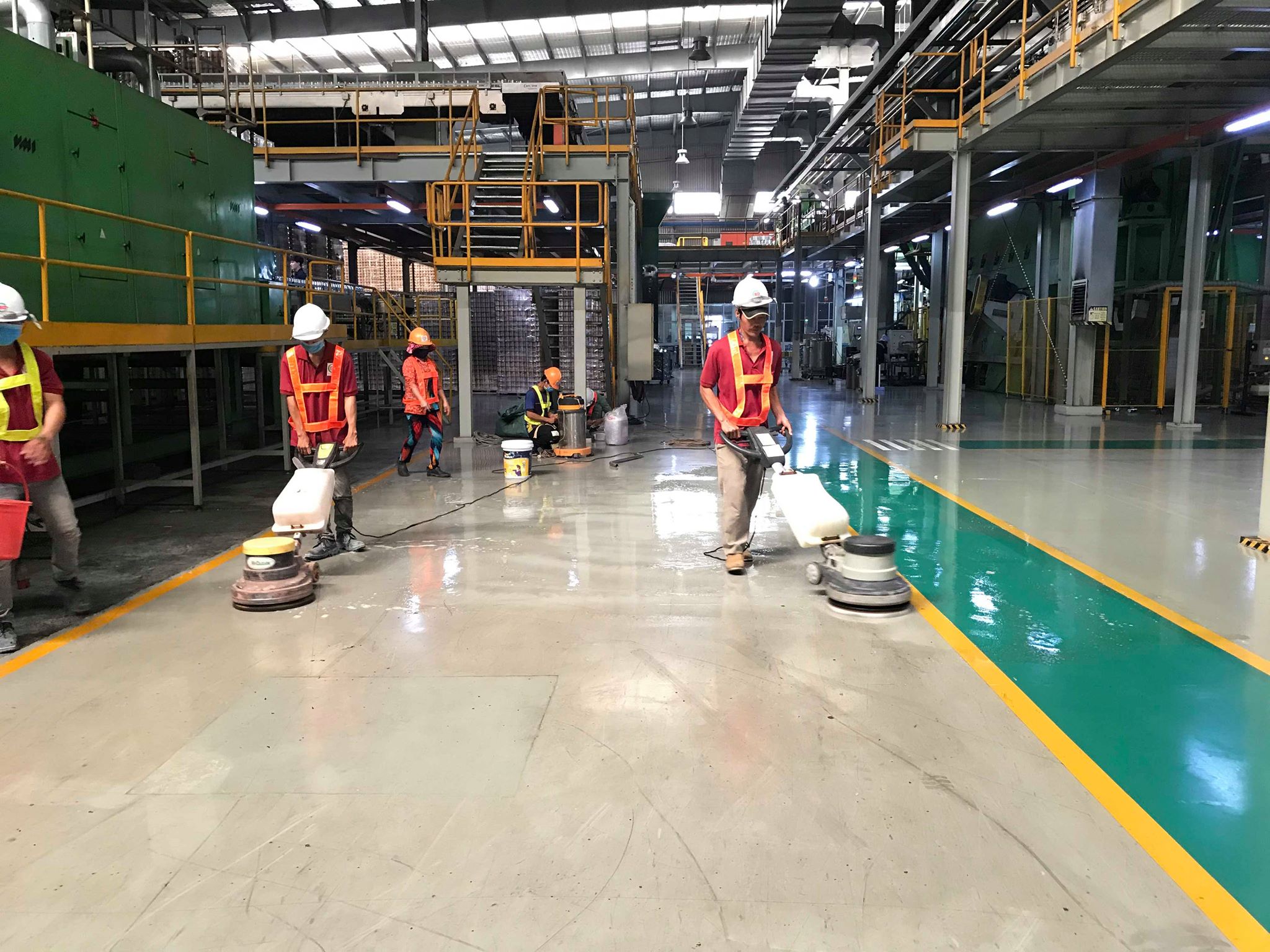 Nhân viên sử dụng máy chà sàn trên sàn nhà xưởng